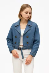 Chaqueta corta color beige con doble botonadura, cuello solapa, cinturón con hebilla rectangular y mangas largas con puños elásticos.