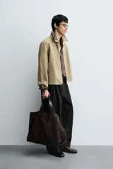 Cazadora regular fit de piel con acabado ante napado, color beige. Sin forro interior, cuello solapa, manga larga, bolsillos de vivo en cadera y cierre frontal con cremallera.