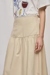 Falda midi de denim color beige, con diseño de volados y caída fluida.