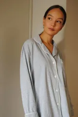 Conjunto de pijama de algodón gris con estampado geométrico blanco, compuesto por una camisa de manga larga con botones y un pantalón largo con elástico en la cintura.