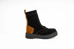 Bota tipo borcego de caña media, confeccionada en una combinación de cuero gamuzado negro y detalles en cuero color suela en la parte trasera y lengüeta. Presenta suela track de goma negra y costuras a la vista.