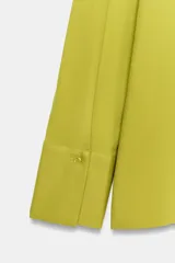 Camiseta verde lima de corte regular, con cuello polo, escote en V y bolsillos de parche en el delantero. Cuenta con mangas largas y puños anchos.