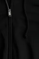 Campera con capucha y cierre frontal, color negro, de corte cropped y holgado, con hombros caídos y puños y bajo acanalados.