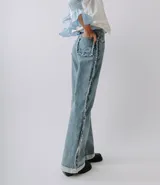 Pantalón de jean celeste de corte recto con detalles desflecados en los laterales y en el bolsillo trasero.