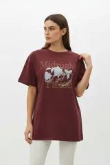 Remera de algodón color negro con cuello redondo y mangas cortas. Presenta un estampado frontal con diseño de rosas, rayos y texto, decorado con detalles de strass.