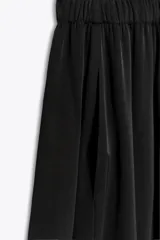 Pantalón fluido de tiro bajo con cintura elástica, confeccionado en tejido ligero con caída, de corte amplio y diseño minimalista.