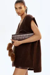 Chaleco de punto suave con textura afelpada, confeccionado en mezcla de lana y mohair. Presenta un corte holgado, cuello en V acanalado y terminaciones con ribete acanalado en sisas y bajo.