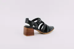 Sandalia de cuero negro con punta cerrada, tiras cruzadas y taco de madera.