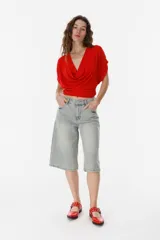 Top verde con escote drapeado y mangas cortas.