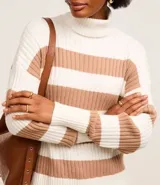 Suéter de punto pesado con cuello alto y mangas largas. Diseño a rayas horizontales en blanco y negro con textura acanalada.