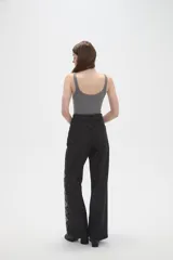 Pantalon de jean negro de corte ancho y tiro alto, con estampado de rombos en los laterales de las piernas.