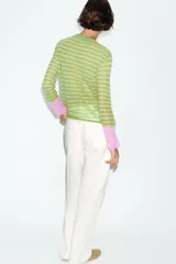 Jersey de punto fino con cuello redondo y manga larga, diseño a rayas horizontales en tonos verdes con puños en contraste de color rosado.