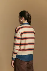 Cardigan de punto con diseño de rayas horizontales en tonos marrón, rosa y beige. Presenta cuello redondo, cierre frontal con botones y mangas largas con puños acanalados.