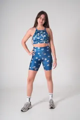 Top deportivo azul con estampado de tréboles blancos y logo de la marca Hermod.