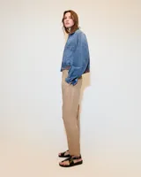 Pantalón babucha negro de tiro medio confeccionado en tela italiana. Presenta cintura elastizada, bolsillos laterales funcionales y piernas tipo pitillo con raya de aplomo.