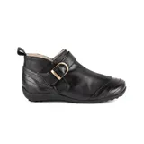 Botita baja Marcel confeccionada en cuero vacuno color marrón, con interior de corderito ultrasuave. Presenta costuras pespunteadas decorativas, tira lateral con hebilla metálica dorada y detalles de elástico negro. Suela plana de goma negra.