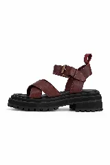 Sandalias Everest de cuero marrón con textura símil serpiente y suela negra plana. Poseen tiras cruzadas en el empeine y tira ajustable con hebilla metálica en el talón.