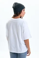 Remera blanca de manga corta con corte amplio (boxy fit) y estampado frontal con el texto "NEW YORK" en letras negras.