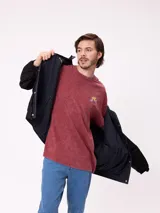 Campera reversible con capucha oculta, confeccionada en sarga de algodón con elastano en el exterior y nylon de poliéster en el interior. Presenta cierre frontal con botones a presión, costuras visibles en contraste y puños elásticos.