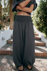 Pantalón baggy de tiro medio color rosado, con cintura elástica fruncida tipo nido de abeja y bajos ajustables con cordones.