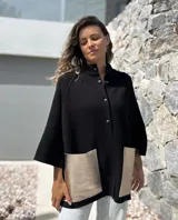 Saco tejido de punto en color negro, con corte holgado y mangas tres cuartos. Presenta bolsillos frontales amplios confeccionados en cuero metalizado color plateado y cierre frontal con botones.