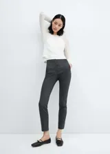 Pantalon de vestir corte skinny, color gris oscuro, con tiro medio, bolsillos laterales y cierre frontal con cremallera y botón.