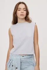 Remera sin mangas negra con cuello redondo y hombros estructurados con hombreras, de corte recto y largo a la cintura.