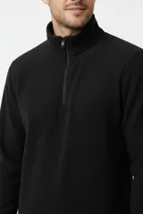 Buzo de polar color negro, con cuello alto y cierre frontal parcial.