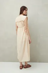 Vestido largo color salmón con estampado abstracto, escote con lazo y mangas cortas. Diseño fluido con frunces en el pecho.