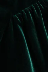 Vestido corto de velour color verde oscuro, con escote cuadrado, breteles anchos y falda acampanada con frunces laterales.