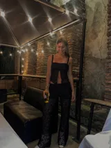 Top de encaje negro con breteles finos y escote con abertura.