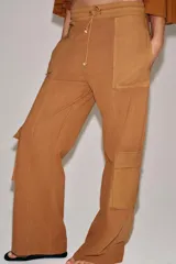 Pantalón cargo de tiro medio con efecto lavado, confeccionado en algodón. Presenta cintura elástica ajustable con cordones, bolsillos laterales y bolsillos de plastrón con solapa en las piernas. Diseño de pierna recta con combinación de tejidos a tono.