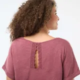 Camiseta de manga corta con cuello en V, confeccionada en tejido crepé de textura sutil. Presenta un diseño holgado con mangas con dobladillo fijo.