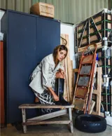 Blazer de cuero color celeste metalizado, con solapas, cierre con broches tipo tanca de madera y puños con detalle de piel sintética marrón.