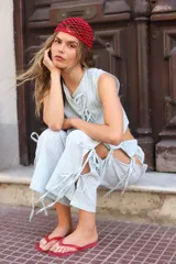 Blusa blanca con lunares negros, cruzada y atada en la cintura.