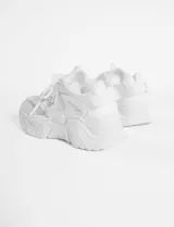 Zapatillas deportivas blancas con suela chunky y detalles de malla.