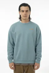 Buzo de cuello redondo en color celeste, con calce relajado y logo de la marca bordado en el pecho en color naranja.