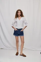 Short de denim color negro con dobladillo fijo, bolsillos delanteros y traseros, de corte clásico.