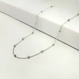 Gargantilla de cadena de eslabones finos con pequeñas esferas intercaladas a lo largo de toda la pieza.