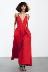 Vestido largo rojo de Zara Woman Collection confeccionado en hilatura con mezcla de algodón. Escote pico y tirantes finos cruzados en la espalda ajustable con lazadas. Tiene bolsillos laterales, detalle de pliegues en la cintura y cierre en la espalda con cremallera oculta en la costura.