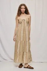 Vestido largo negro de algodón, con breteles finos, escote con frunce y lazo regulable. Tiene cintura definida y falda amplia escalonada, con detalles bordados verticales en contraste.