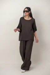 Blusa de lino color beige, de calce cómodo y relajado, con cuello redondo, mangas cortas y detalle de alforzas y guarda bordada en el lateral.