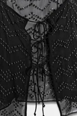 Top color beige con escote cuadrado y tirantes finos. Diseño con tachuelas combinadas a tono y cierre en la espalda con lazadas.