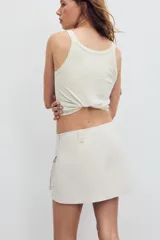 Falda pantalón satinada de tiro medio y color negro, con bolsillos cargo de plastrón con solapa, pliegues decorativos en el delantero y cierre lateral con cremallera oculta.