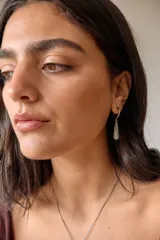 Aros colgantes de acero quirúrgico plateado con dije de piedra natural rosa en forma de lágrima.