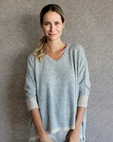 Sweater celeste de lana lambswool con cuello en V y mangas 3/4 con puños acanalados en color crema.