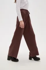 Pantalon de viscosa color verde militar, de corte ancho y tiro medio, con cintura elástica y cordón ajustable.