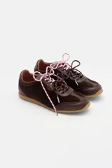 Zapatilla de cuero marrón con paneles de gamuza y cuero liso, suela de goma color caramelo y cordones bicolores en rosa y blanco.