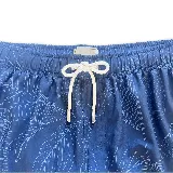 Short de baño negro con estampado botánico de hojas en líneas finas blancas. Cuenta con cintura elástica con cordón ajustable, dos bolsillos laterales y uno trasero.