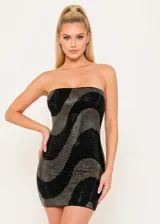 Vestido corto strapless con diseño de patrón ondulado en colores negro y dorado. La prenda presenta un acabado brillante con pedrería que cubre toda la superficie, creando un efecto visual dinámico.